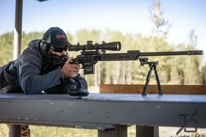 Prone with bipod, suppressed rifle on the bench