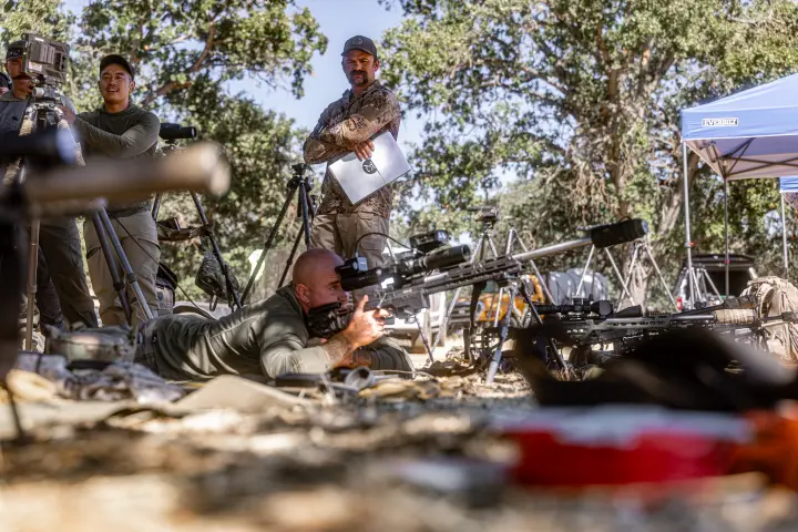 Shooter prone on the line as instructor watches