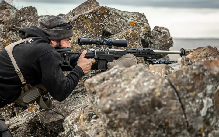 Prone in coastal rocks behind the scope