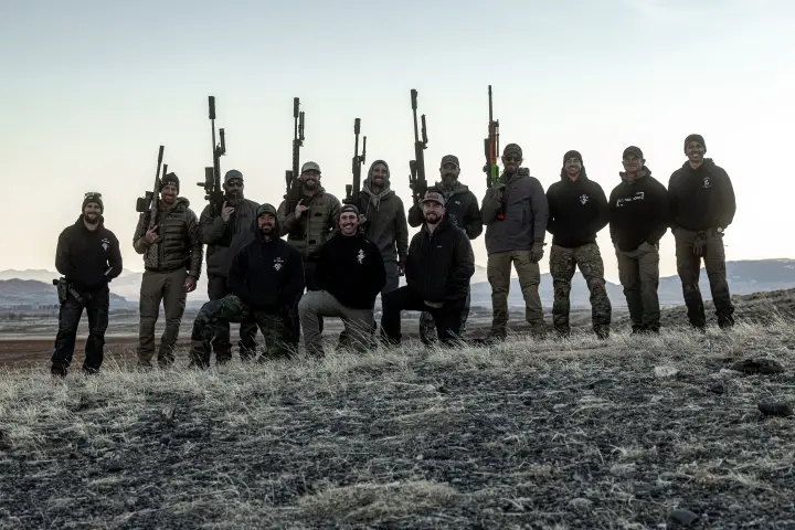 Group photo with rifles raised at dusk