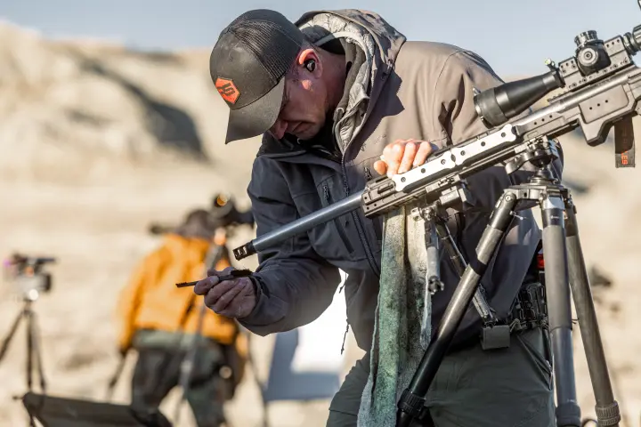 Shooter inspecting his rifle and bolt