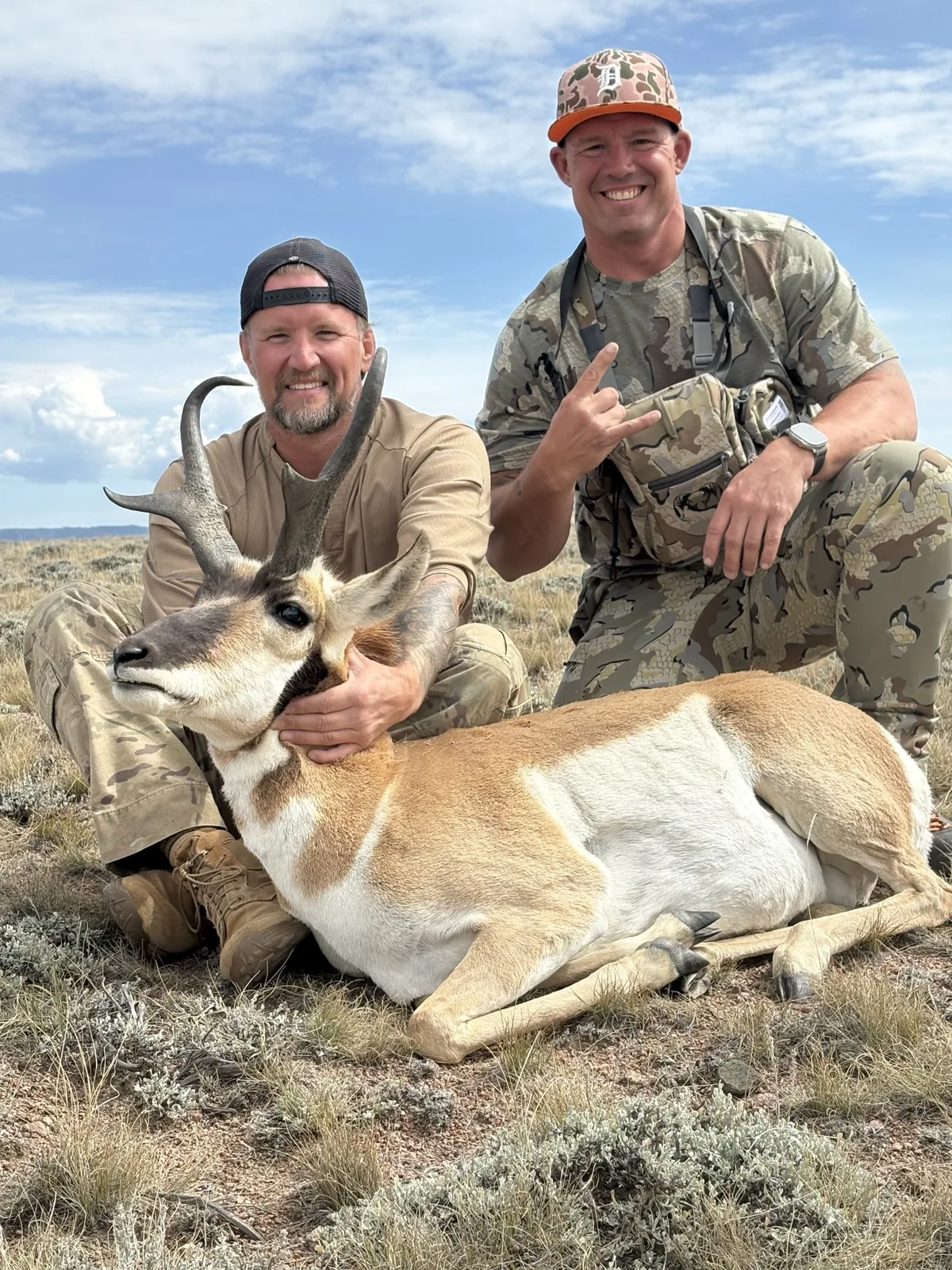 Eric Avvisato kneeling behind a harvested antelope on open ground