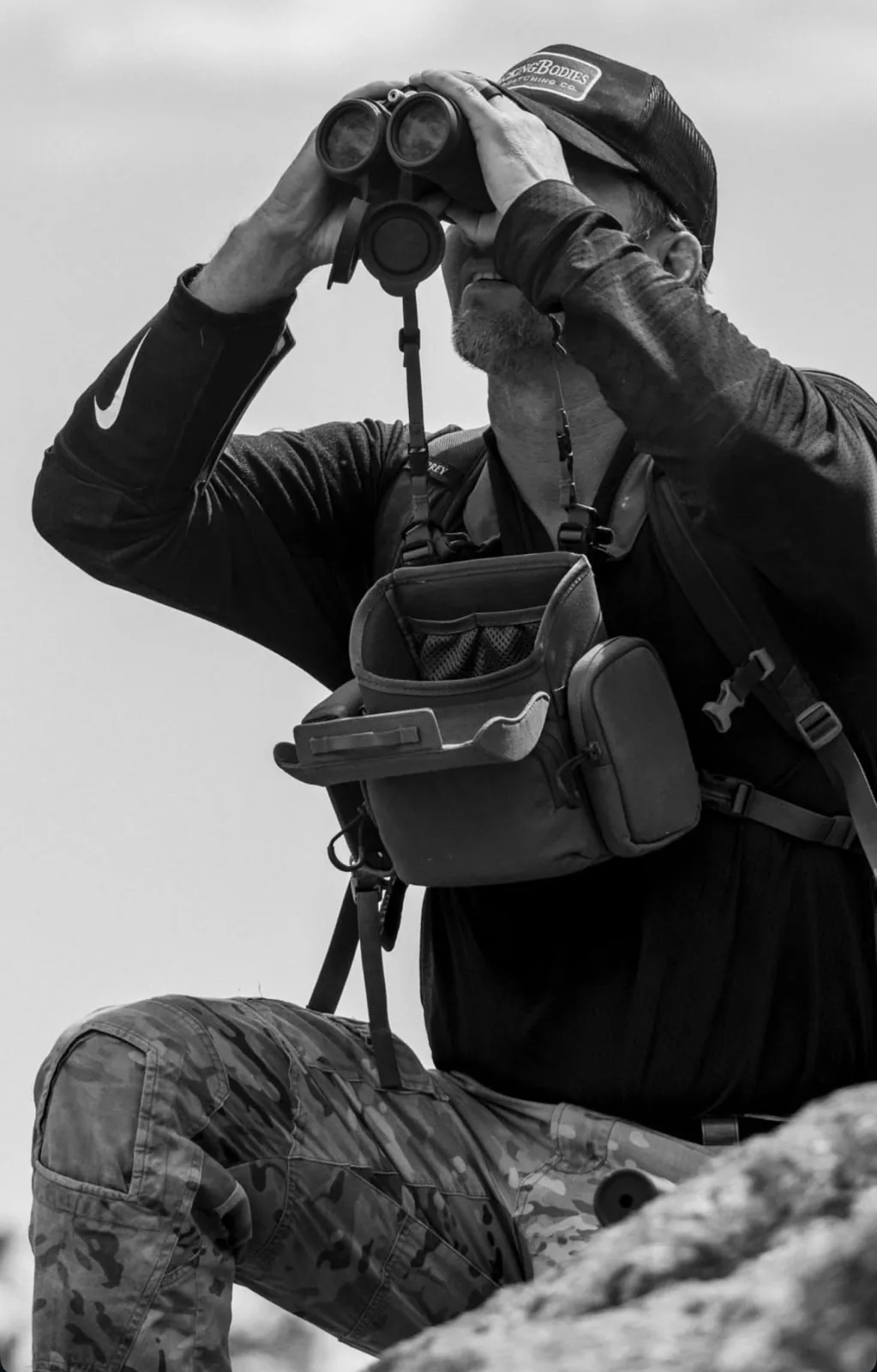 Eric Avvisato glassing for game through binoculars in a chest harness