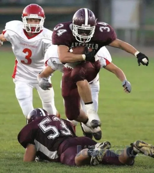 A young Ian Miner carrying the ball in his Wakefield high school football uniform