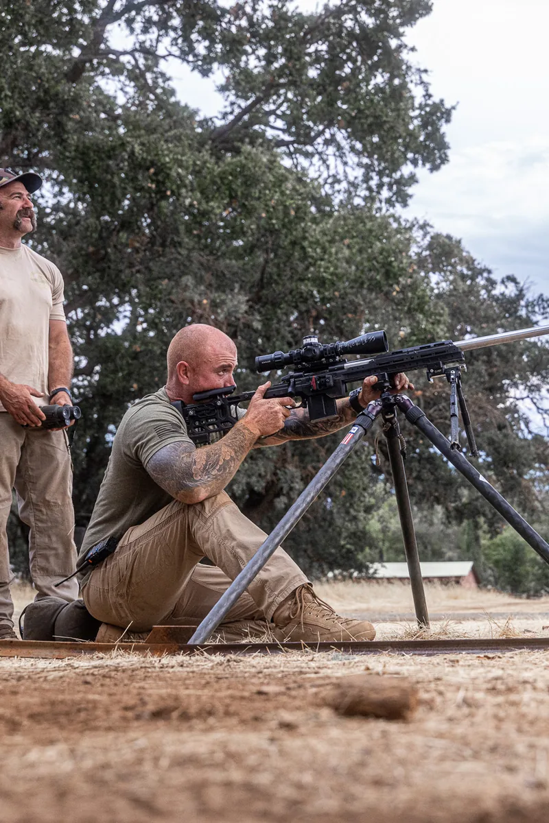 Jon Bumpus demonstrating a seated tripod position while another instructor spots