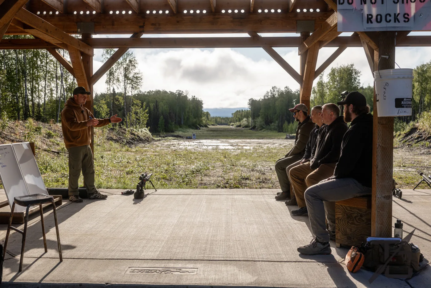 Matt Solowynsky teaching a small group of students under a range shelter in Alaska