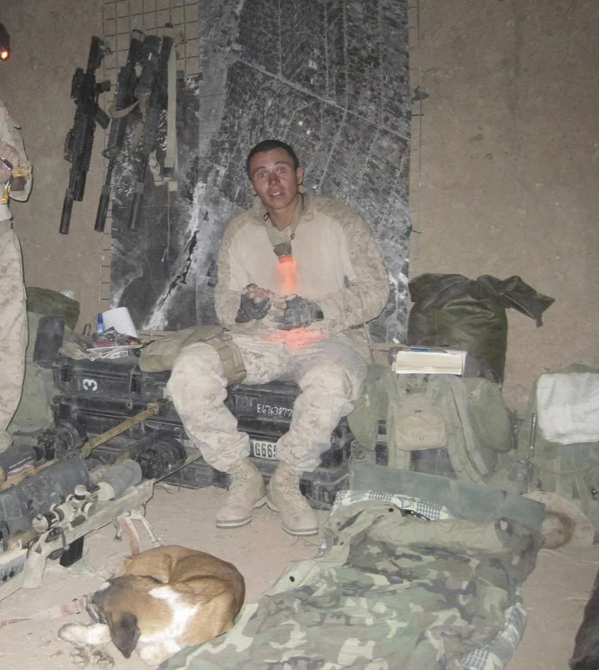 Patrick Trujillo seated with field equipment during his Marine Corps service