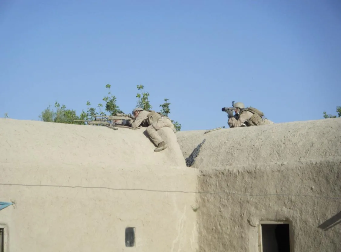 A Marine Scout Sniper team in position on a rooftop
