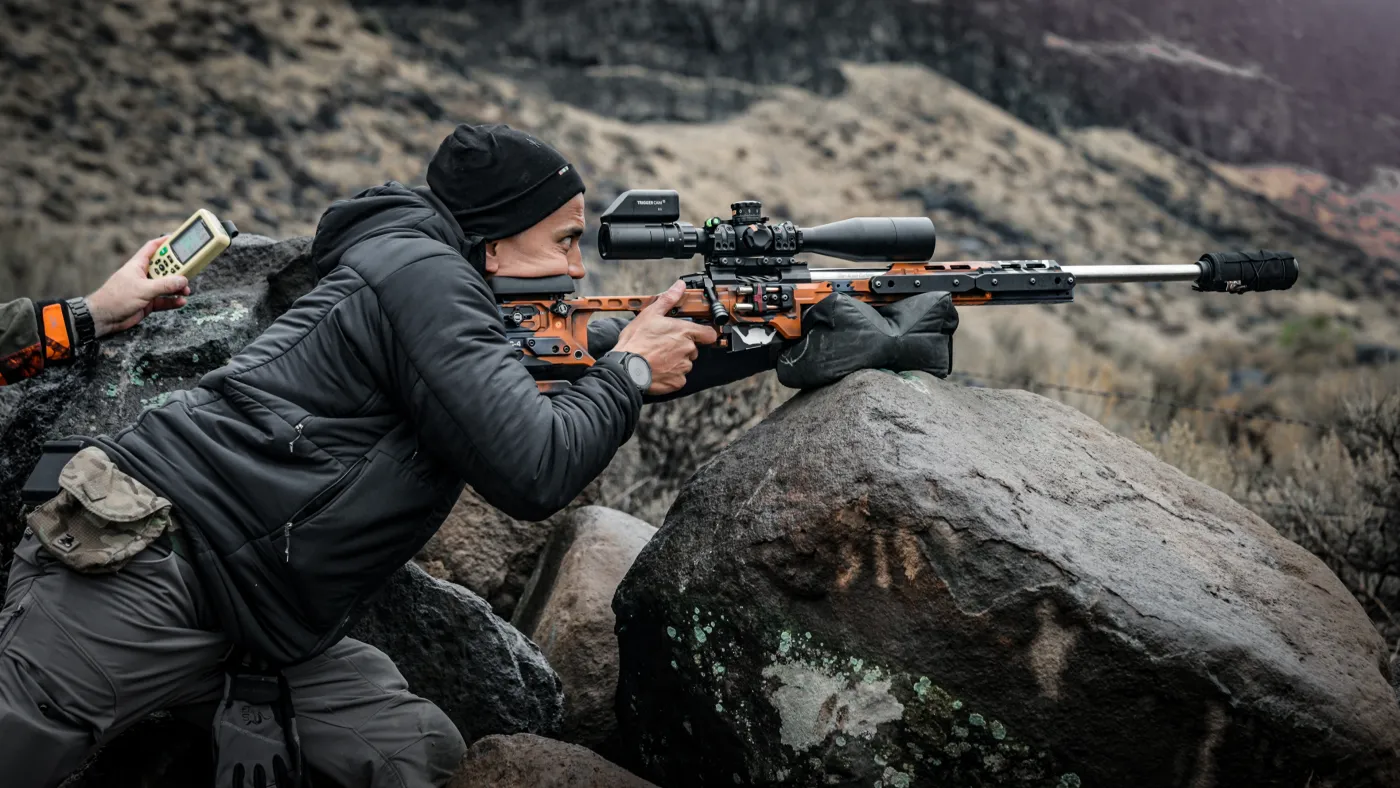 Phil Velayo building a shooting position over boulders behind a chassis precision rifle