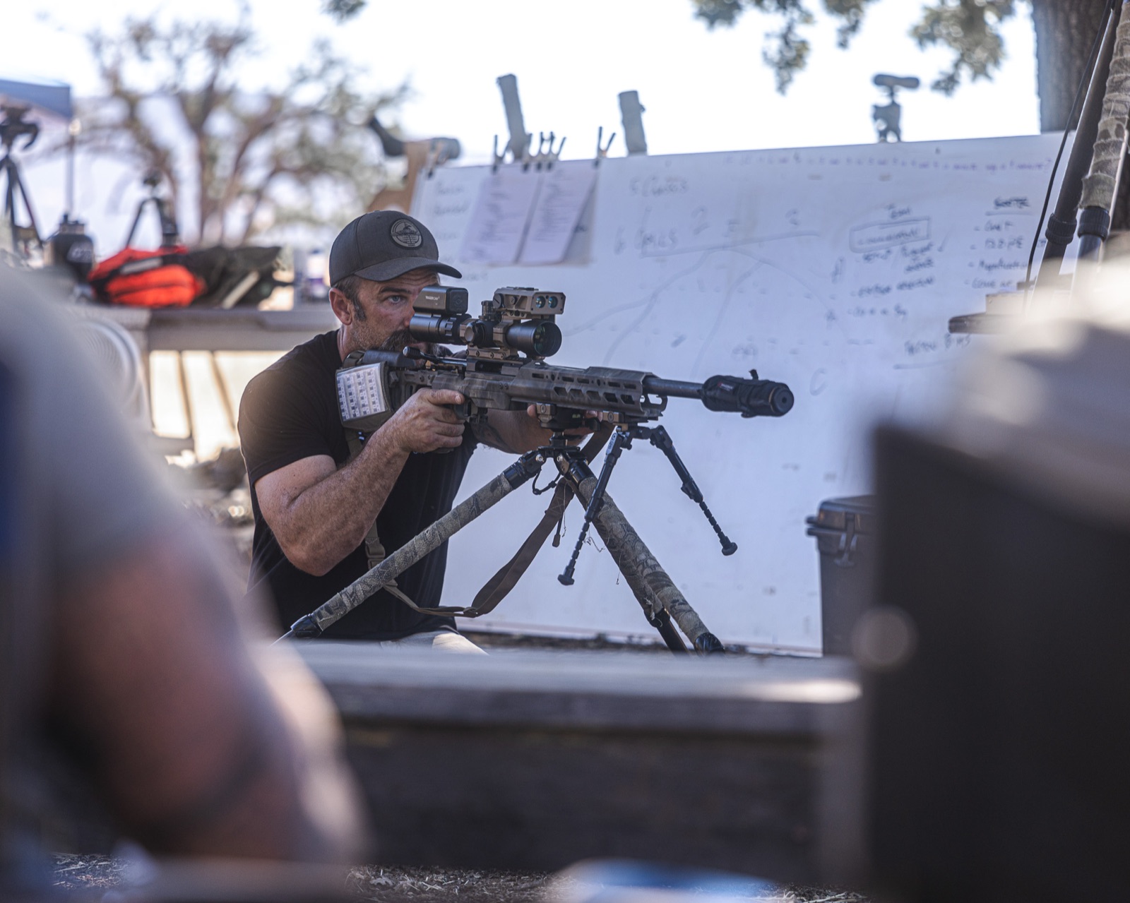 Steve Holland building a prone position behind a bipod-mounted precision rifle on the firing line