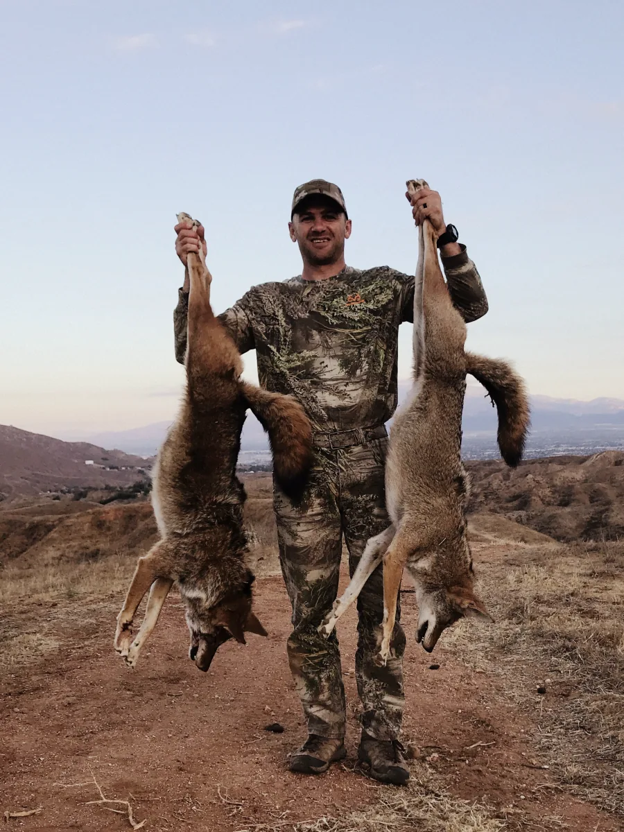 Steve Holland holding two coyotes taken on a Southern California hunt