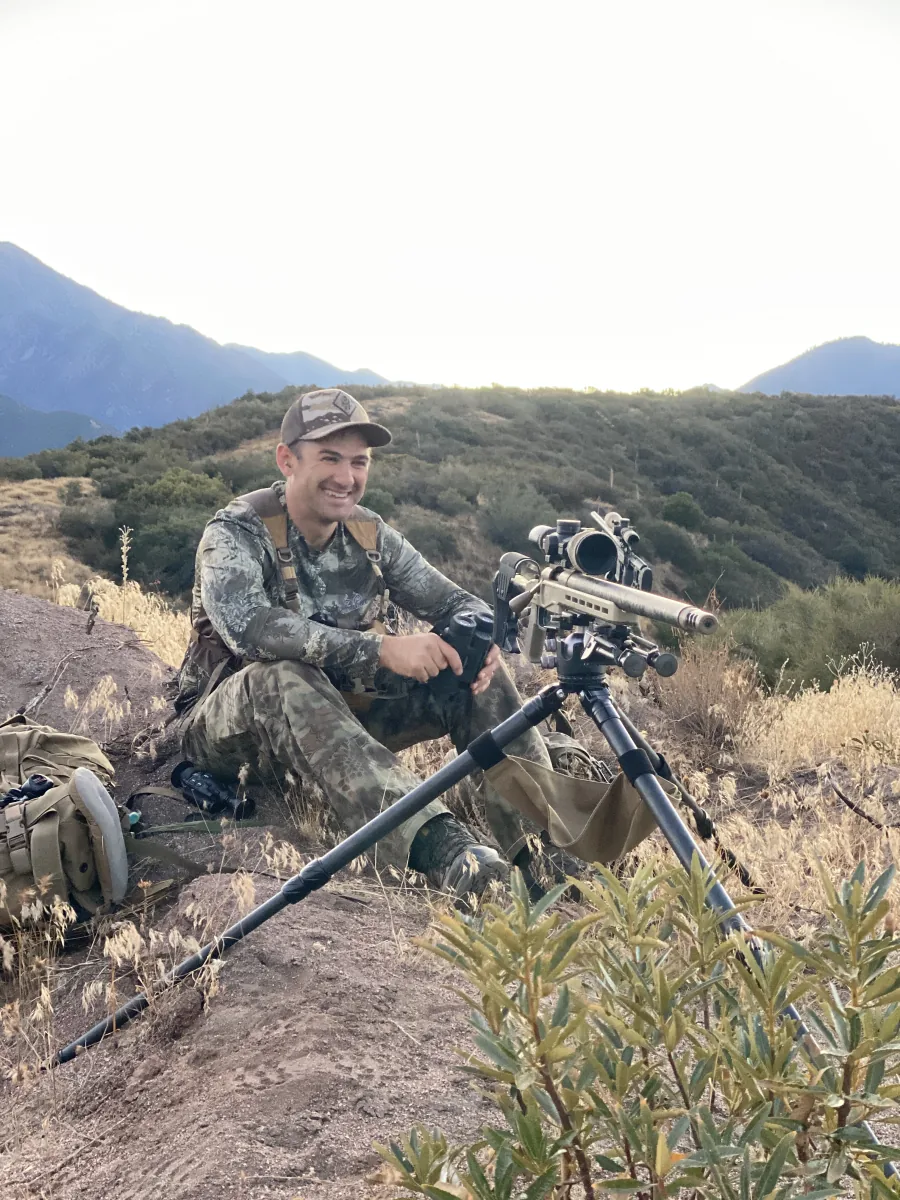 Steve Holland glassing from a tripod-mounted precision rifle while coyote hunting in Southern California