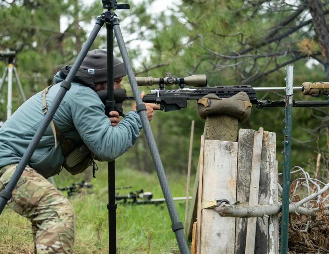 Instructor shooting from a front support bag on a field barricade.